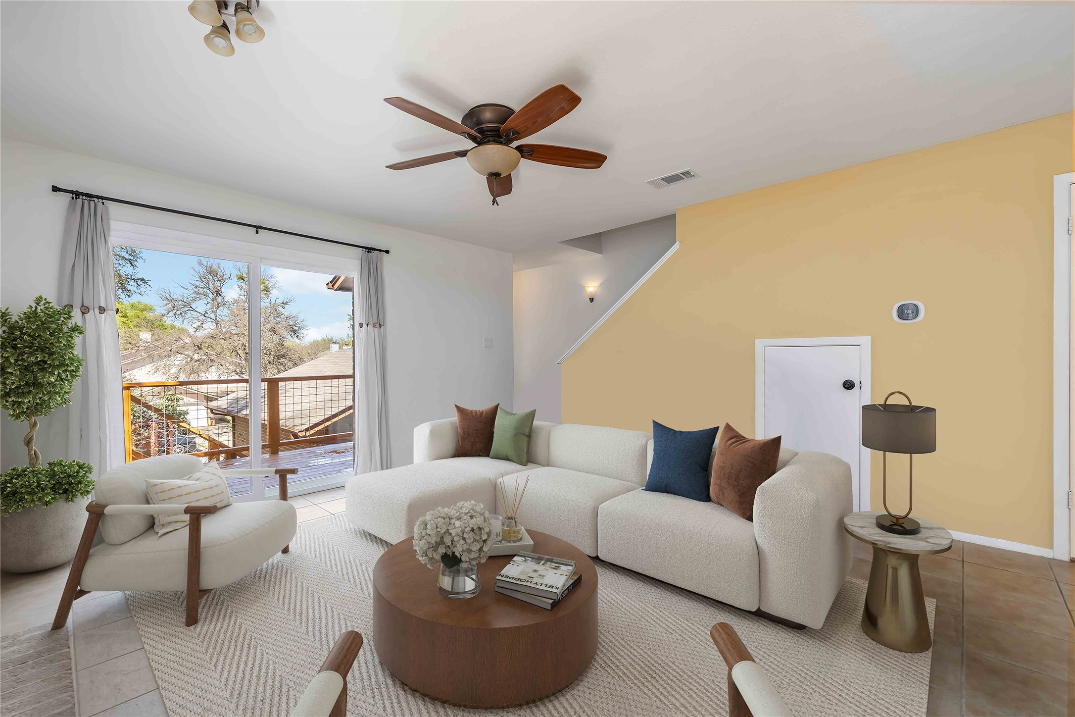 Living area featuring a ceiling fan and light tile patterned flooring