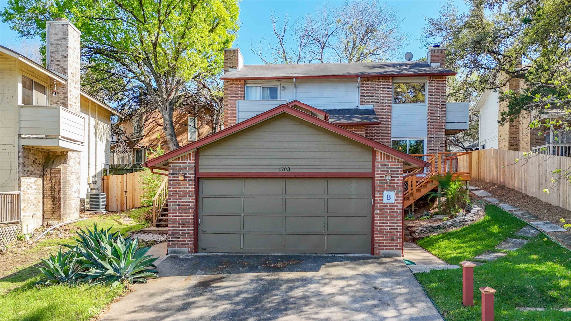 1703 Waterloo Trail, Unit B Austin, TX 78704 - Photo 30 of 36 View of front facade featuring brick siding, driveway, and a chimney