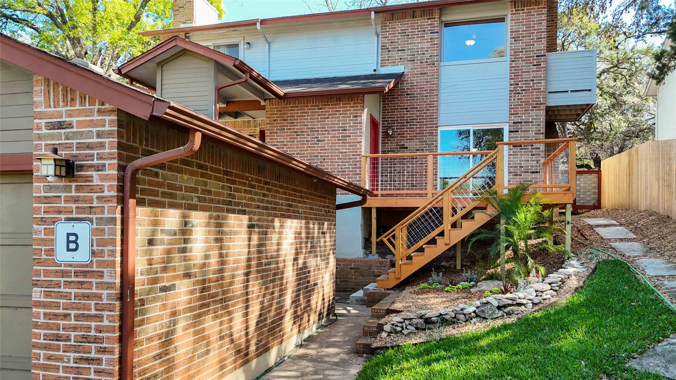 1703 Waterloo Trail, Unit B Austin, TX 78704 - Photo 31 of 36 Back of property with brick siding, a wooden deck, and a garage