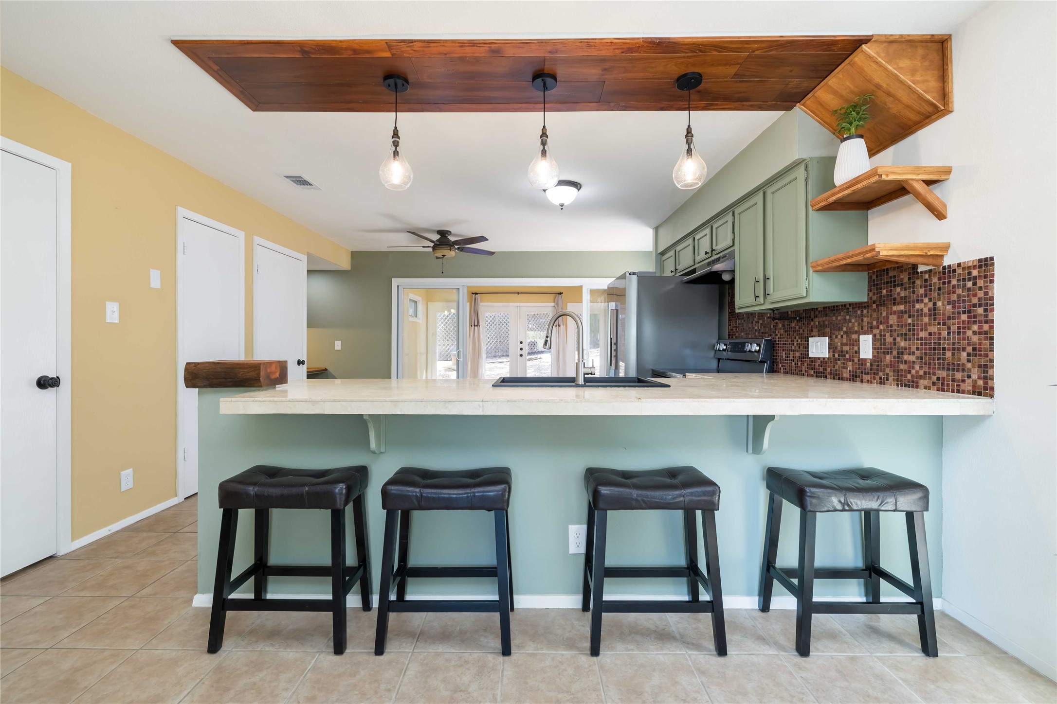 1703 Waterloo Trail, Unit B Austin, TX 78704 - Photo 4 of 36 Kitchen featuring green cabinets, a peninsula, open shelves, and pendant lighting