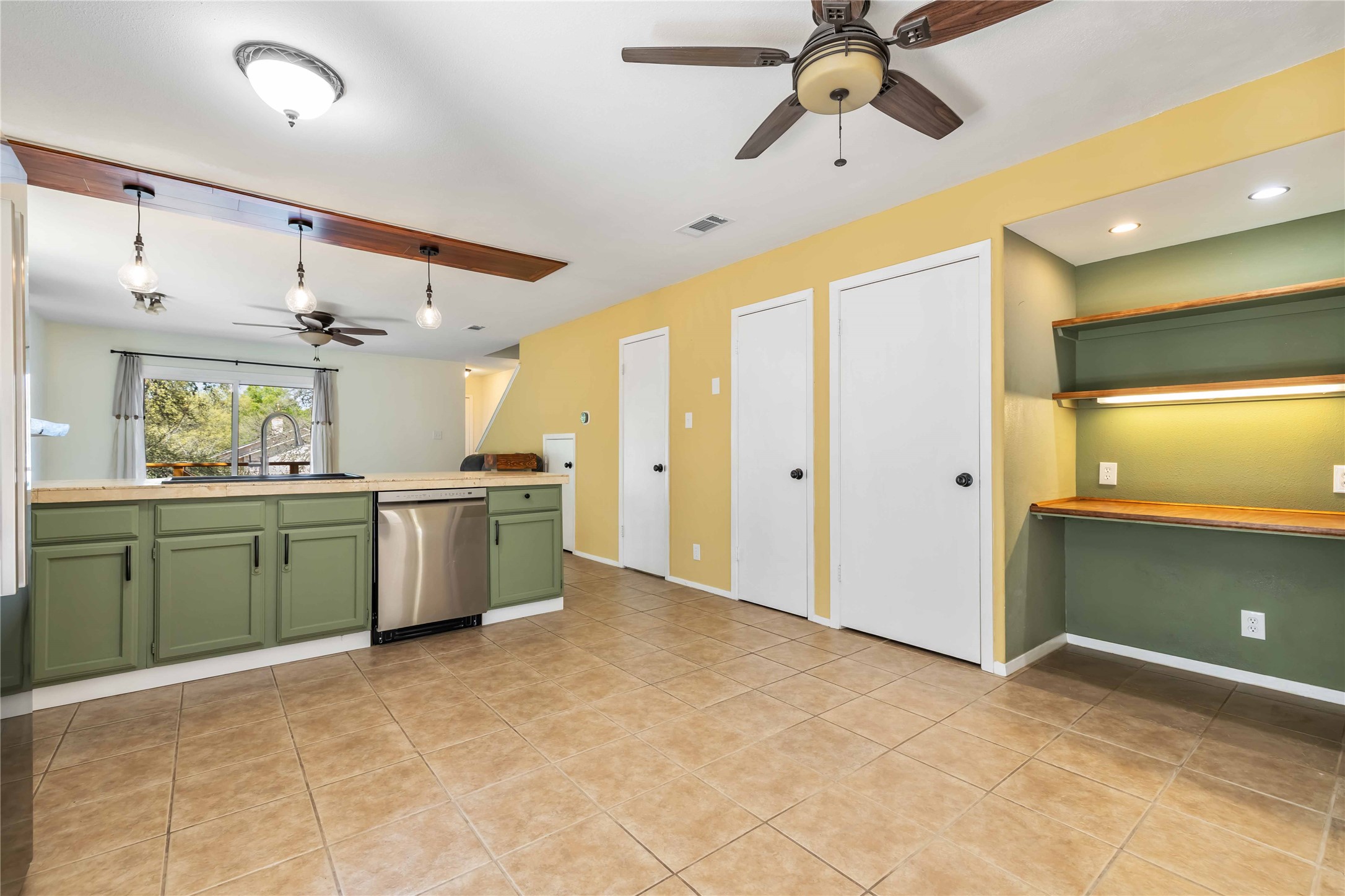 1703 Waterloo Trail, Unit B Austin, TX 78704 - Photo 6 of 36 Kitchen with a ceiling fan, green cabinets, light countertops, stainless steel dishwasher, and decorative light fixtures