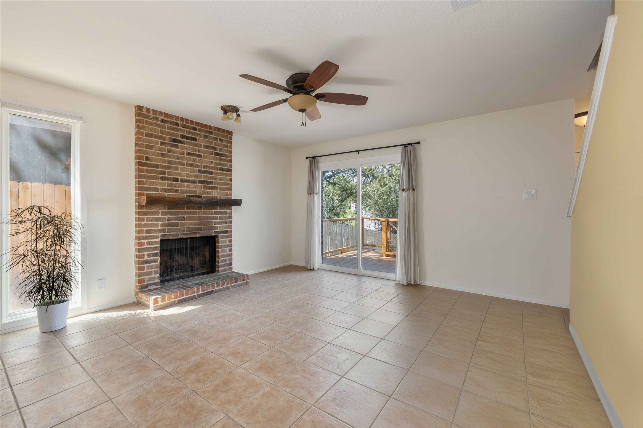 1703 Waterloo Trail, Unit B Austin, TX 78704 - Photo 8 of 36 Unfurnished living room with light tile patterned floors, a ceiling fan, and a fireplace