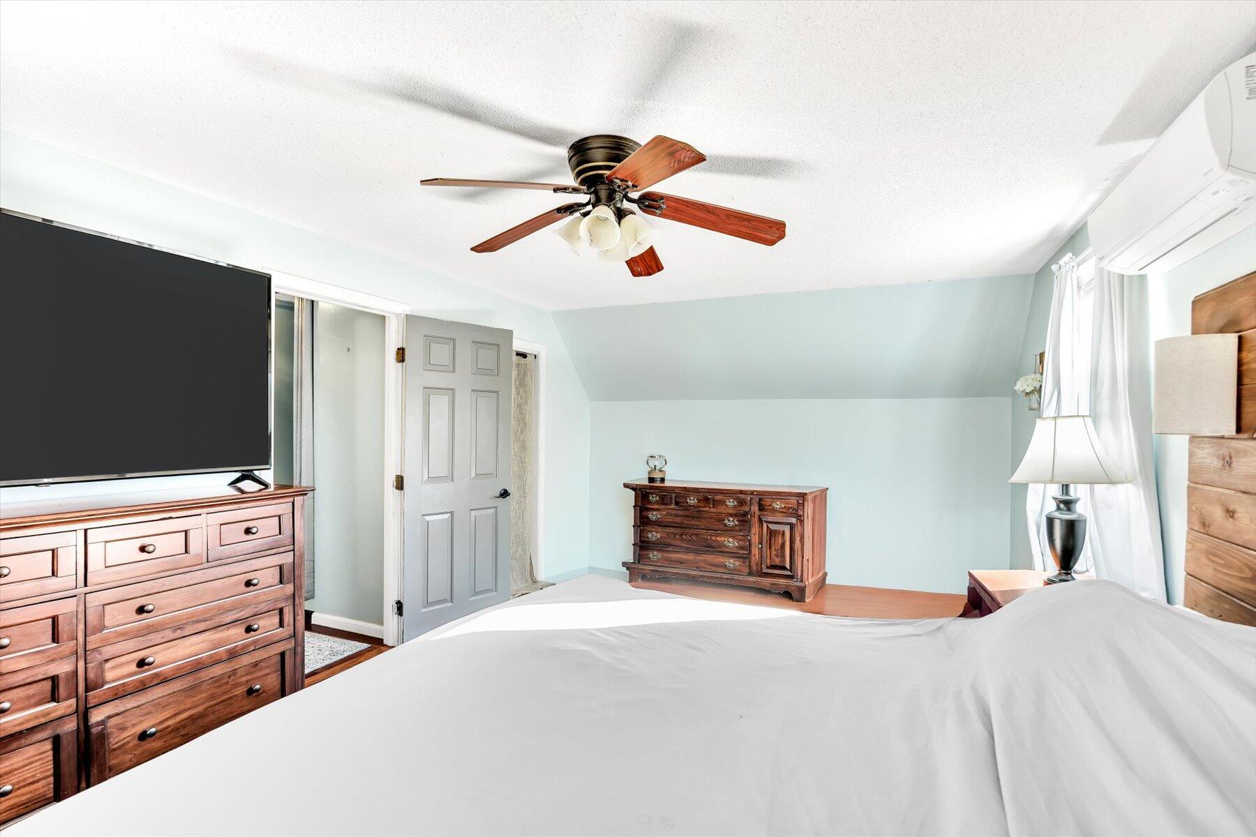 39 Papnomett Road Mashpee, MA 02649 - Photo 16 of 34 a bedroom with a bed and a flat tv screen on dresser