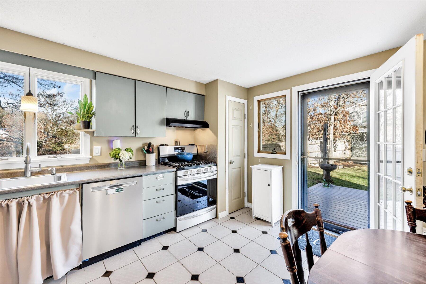 39 Papnomett Road Mashpee, MA 02649 - Photo 9 of 34 a kitchen with white cabinets a sink a stove and a refrigerator