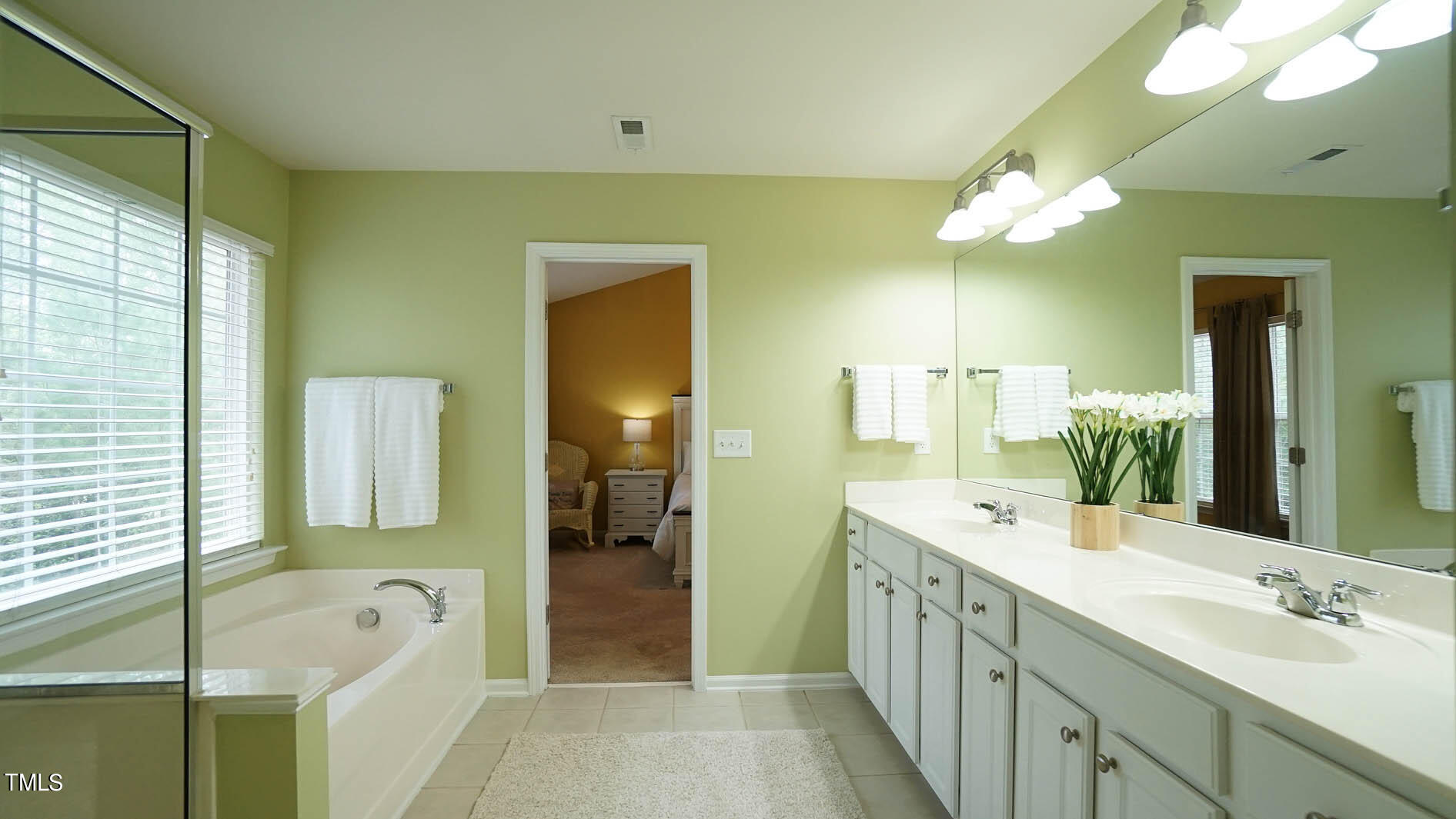 3318 Colorcott Street Raleigh, NC 27614 - Photo 25 of 28 a spacious bathroom with a double vanity sink a large mirror and shower