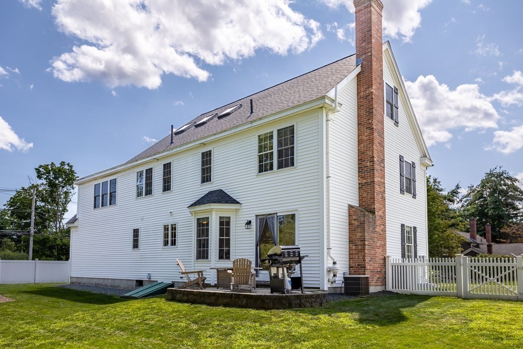 1 Sarah Lane Maynard, MA 01754 - Photo 36 of 40 a front view of a house with large windows and a yard