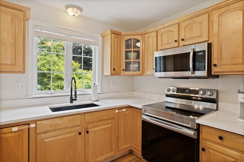 1 Sarah Lane Maynard, MA 01754 - Photo 6 of 40 a kitchen with stainless steel appliances granite countertop white cabinets and a stove top oven