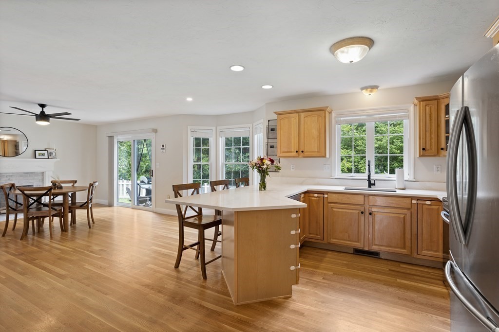 1 Sarah Lane Maynard, MA 01754 - Photo 7 of 40 a kitchen with stainless steel appliances granite countertop a table chairs and a refrigerator