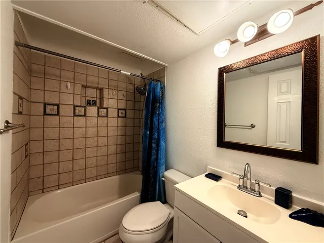a bathroom with a bathtub shower sink vanity and toilet