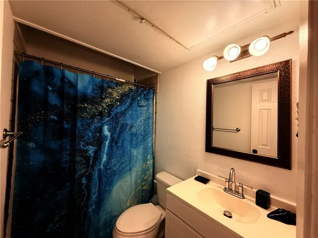 a bathroom with a sink vanity mirror and toilet