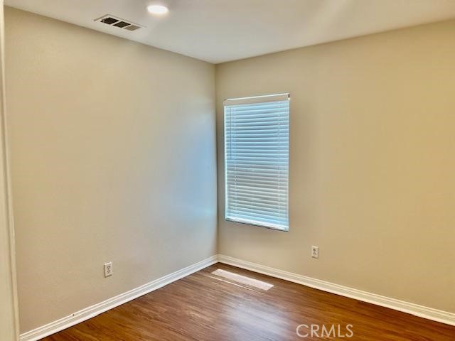 14566 Rochester Avenue Chino, CA 91710 - Photo 15 of 33 a view of an empty room with wooden floor and a window