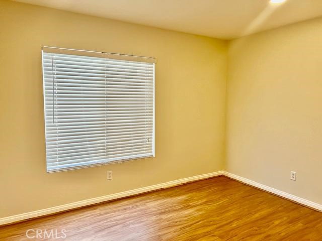 14566 Rochester Avenue Chino, CA 91710 - Photo 18 of 33 a view of an empty room with wooden floor and a window