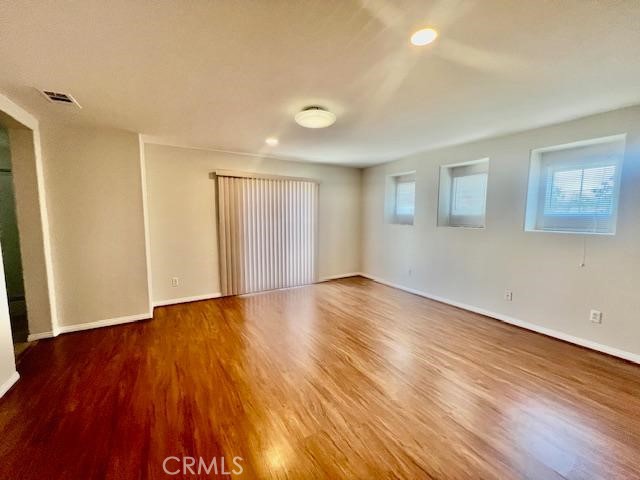 14566 Rochester Avenue Chino, CA 91710 - Photo 21 of 33 a view of an empty room with wooden floor and a window