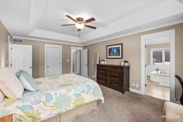 a spacious bedroom with a bed and a chandelier