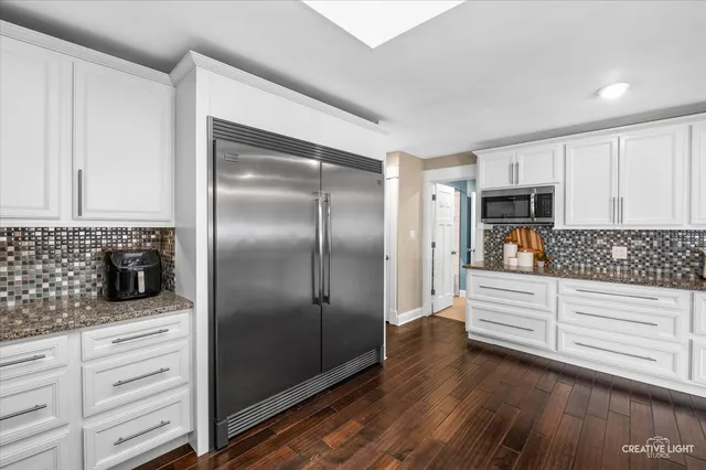 a kitchen with white cabinets and stainless steel appliances