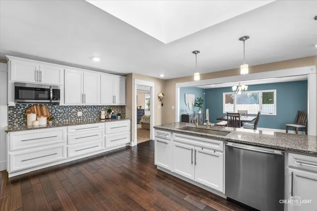 a kitchen with granite countertop white cabinets and white appliances