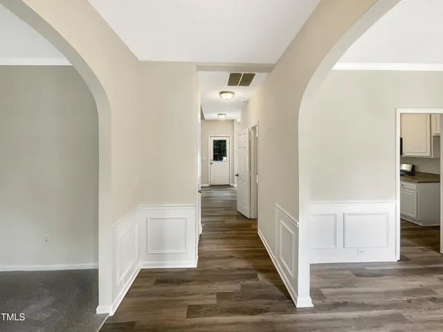 a view of a hallway with wooden floor and staircase