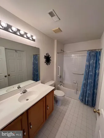 a bathroom with a sink a toilet a mirror and shower