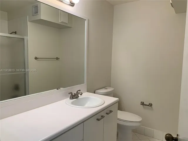 a bathroom with a double vanity sink toilet and shower