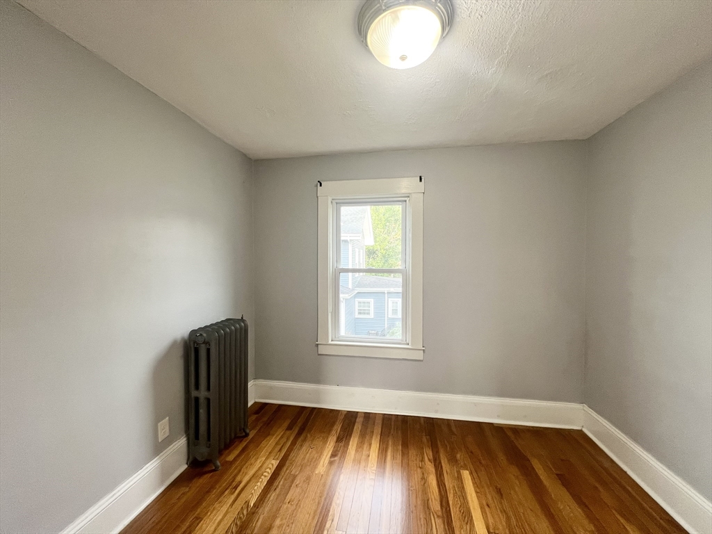 79 Franklin Street, Unit 2 Stoneham, MA 02180 - Photo 11 of 16 an empty room with wooden floor and windows