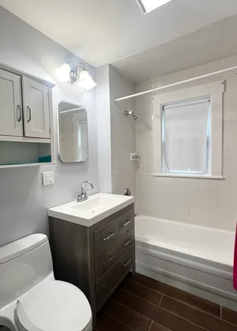 a bathroom with a tub sink and mirror