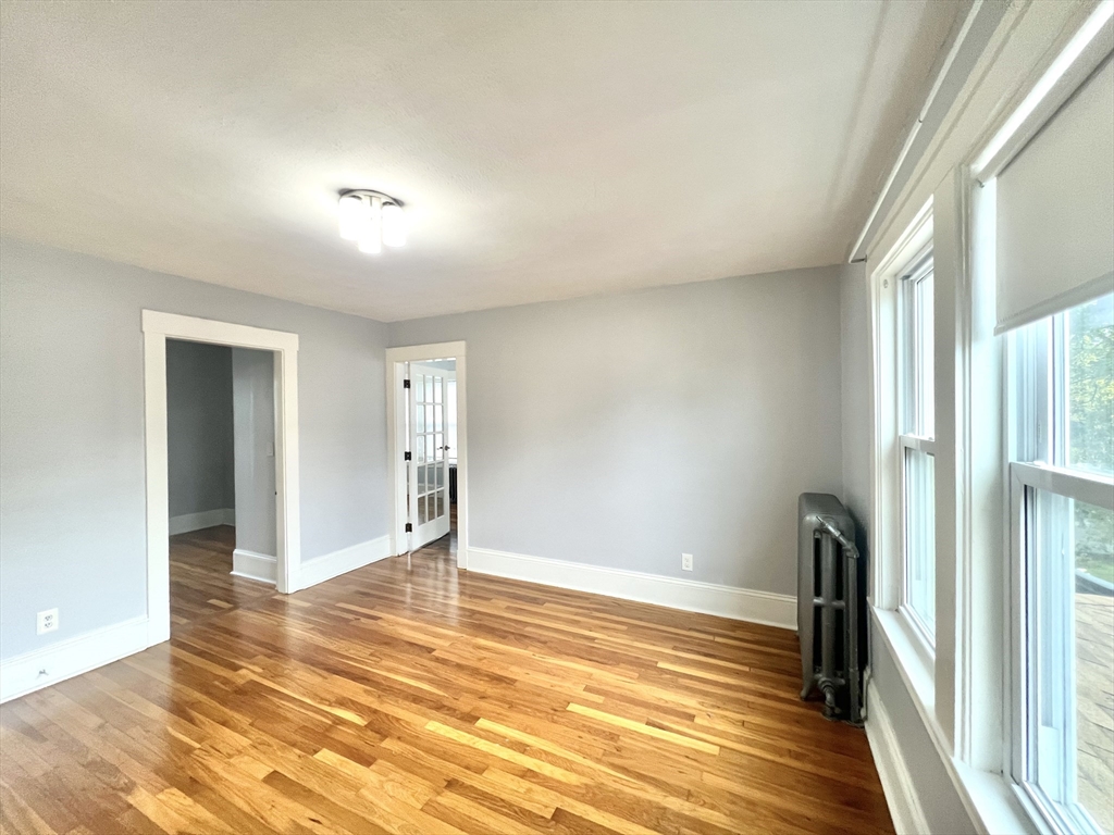 79 Franklin Street, Unit 2 Stoneham, MA 02180 - Photo 10 of 16 a view of empty room with wooden floor and fan