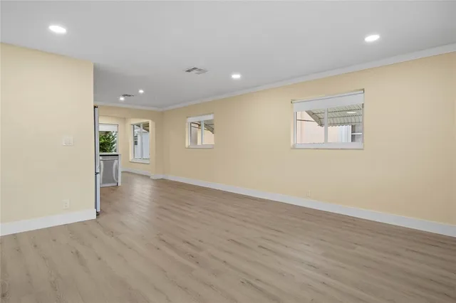 an empty room with wooden floor and a window