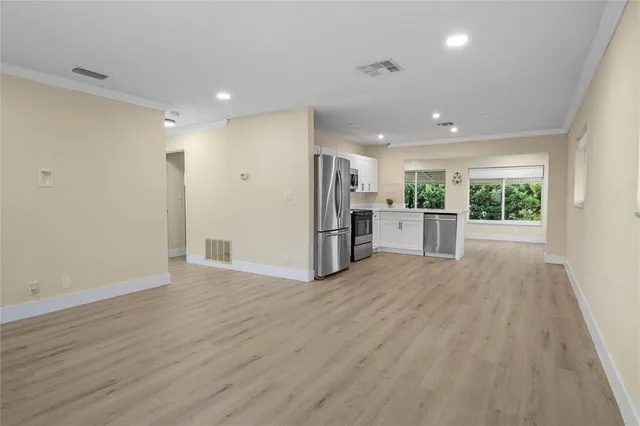 a view of a electric appliances in kitchen and an empty room