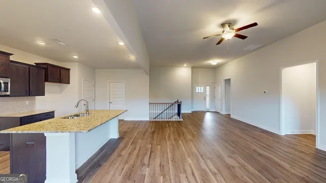 a open kitchen with kitchen island a large counter top space a sink and appliances