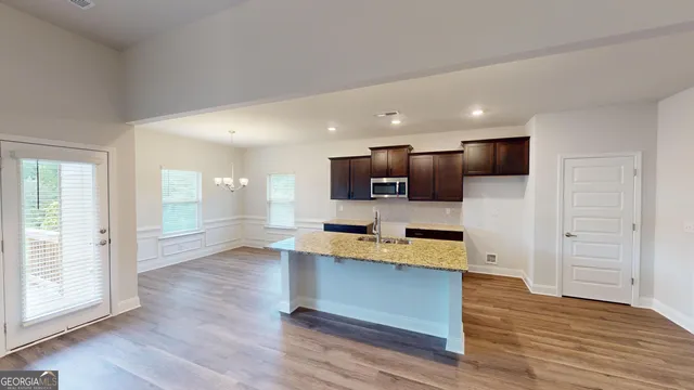 a view of kitchen with microwave stove refrigerator and wooden floor