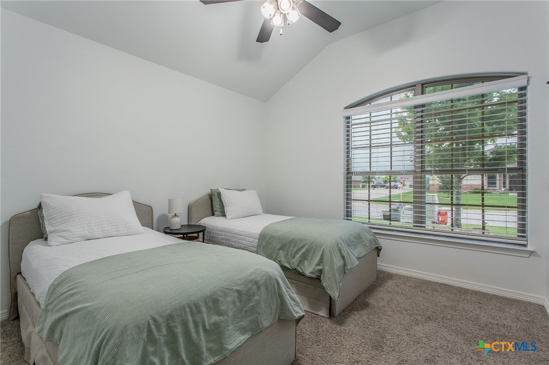 8304 Split Trl Cove Temple, TX 76502 - Photo 13 of 28 a spacious bedroom with two beds and a chandelier
