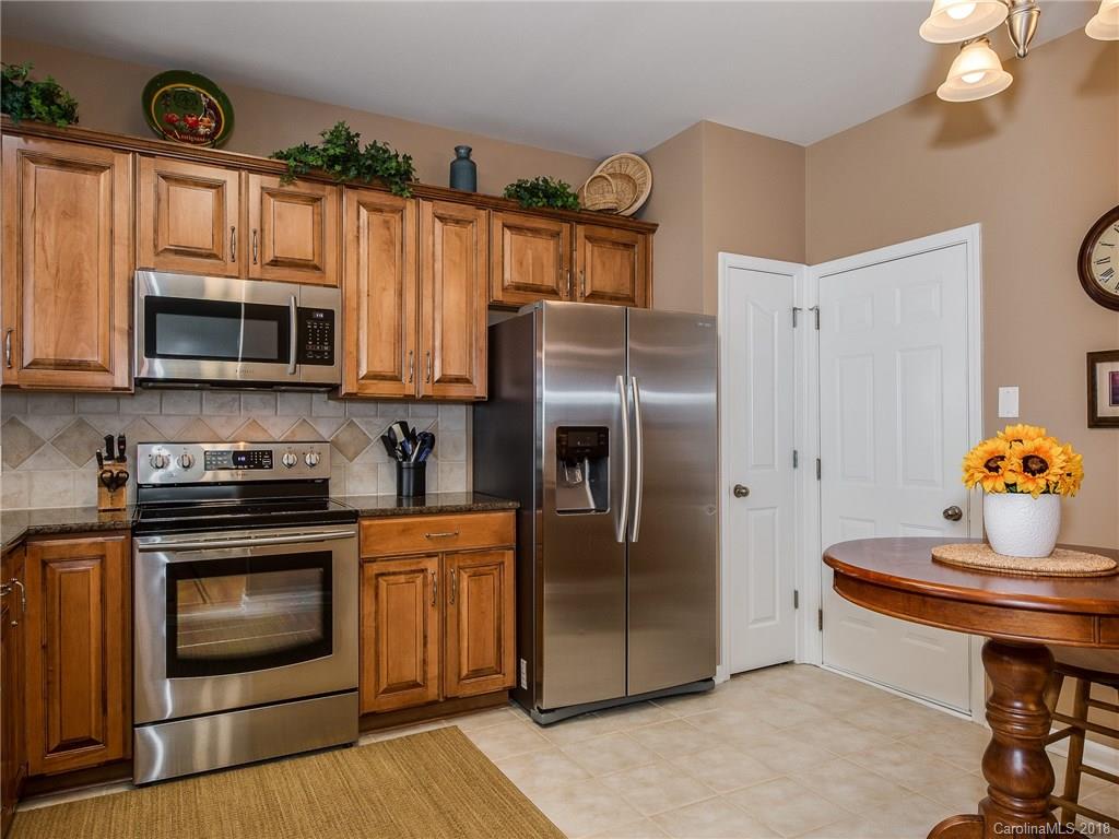 9176 Redmond Trace Road Charlotte, NC 28277 - Photo 10 of 24 a kitchen with granite countertop a stove top oven a sink and dishwasher