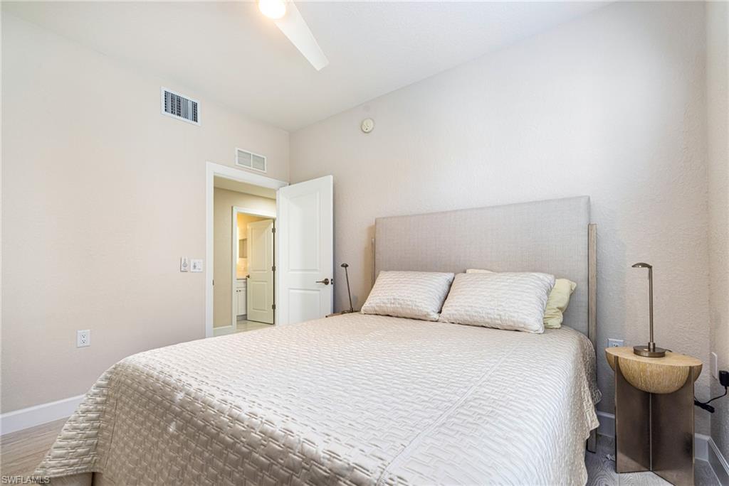 19071 Ridgepoint Drive, Unit 102 Estero, FL 33928 - Photo 18 of 50 a bedroom with a bed and a table