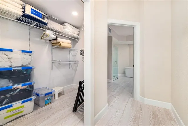 a view of walk in closet with clothes and shoes