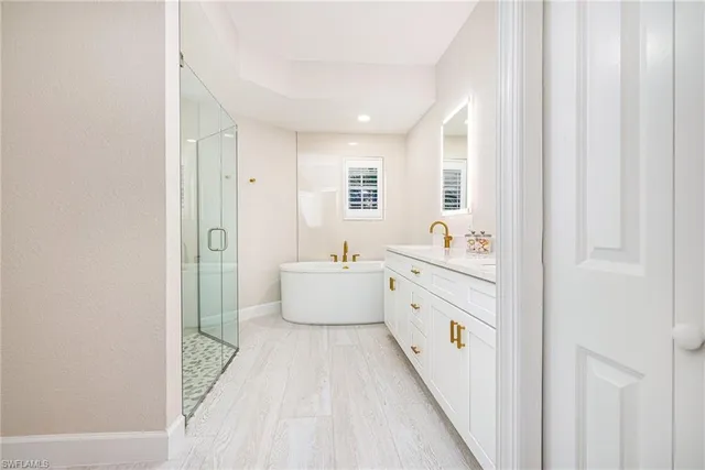a bathroom with a sink a tub and mirror
