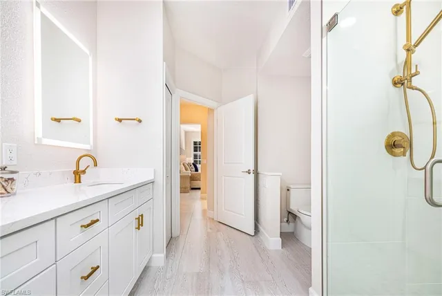 a bathroom with a granite countertop sink a mirror and a shower
