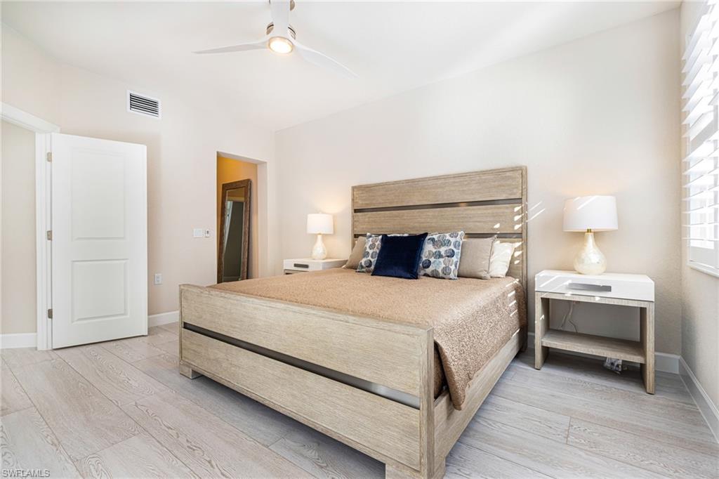 19071 Ridgepoint Drive, Unit 102 Estero, FL 33928 - Photo 26 of 50 a bedroom with a bed and a night stand
