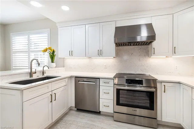 a kitchen with cabinets appliances and a sink
