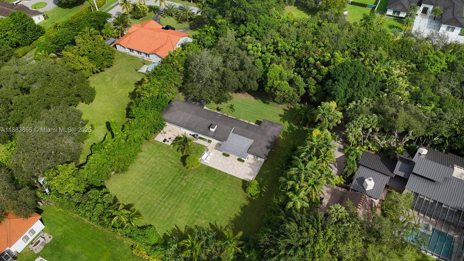 an aerial view of residential house with outdoor space and trees all around