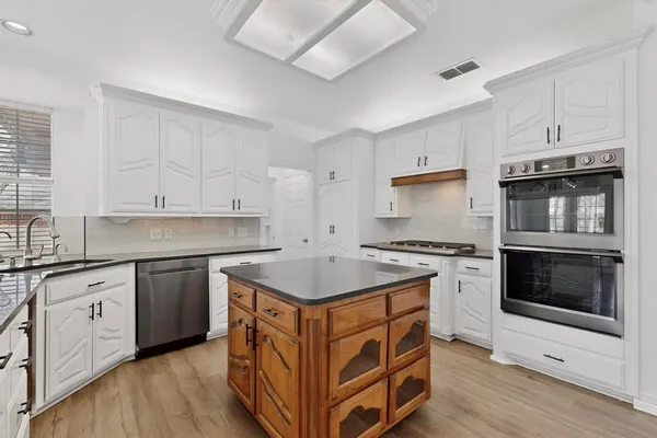 a kitchen with stainless steel appliances granite countertop a stove and a sink