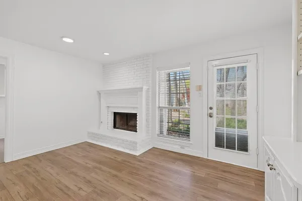 an empty room with wooden floor and fireplace