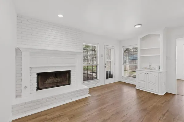 a living room with a fireplace and wooden floor