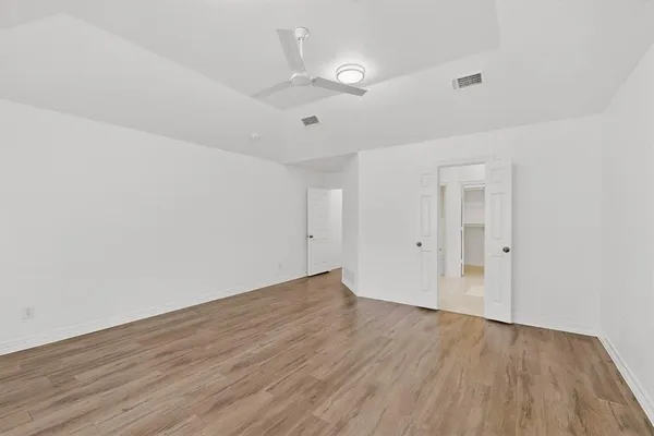 a view of an empty room with wooden floor