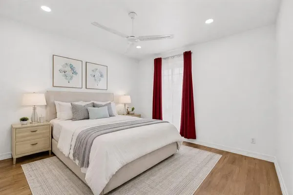 a bedroom with a large bed and a wooden floor