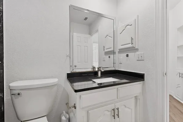 a bathroom with a granite countertop sink and a mirror
