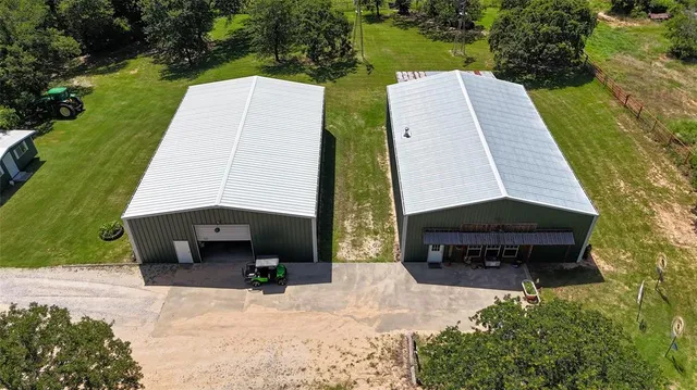 an aerial view of a house with garden space and a car parked