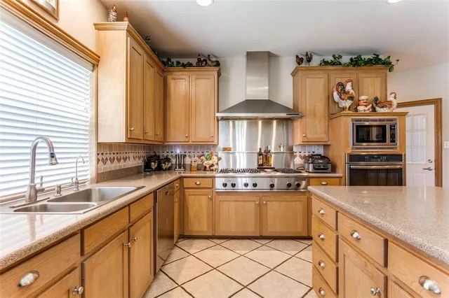 a kitchen with stainless steel appliances a sink stove and cabinets