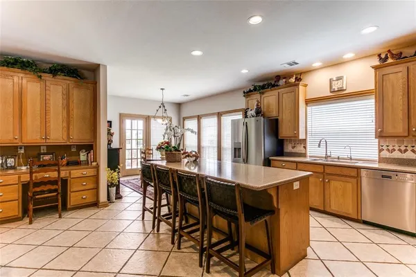 a dining hall with stainless steel appliances a table and chairs