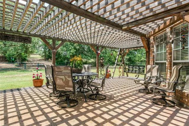 a view of a patio with a table chairs and backyard