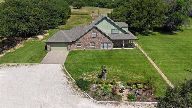 a aerial view of a house with a yard and potted plants